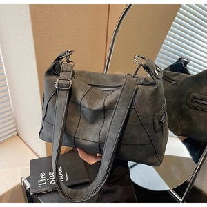 Close-up of vintage frosted charcoal shoulder bag with contrast stitching and metal zippers