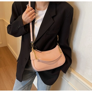 Detail of pink woven texture underarm bag with gold chain and leather shoulder strap