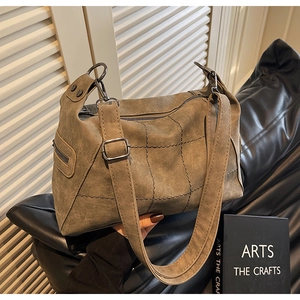 Macro view of suede vintage tote showing decorative stitching and side zipper detail