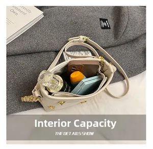 Detail view showing beige leather crossbody bag interior with phone and cosmetics capacity