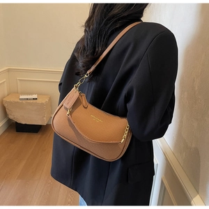 Detail of caramel woven hobo bag with gold hardware and signature logo branding