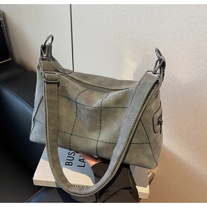 Close-up of matte dark green tote bag with unique diamond quilting and metal buckle