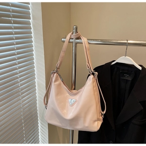 Close-up of light pink tote bag with silver triangle metal hardware and leather texture