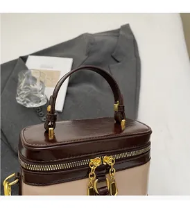 Detail der zweifarbigen Vintage-Box-Tasche mit goldenen Reißverschlüssen und Nähten