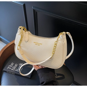 Close-up of cream woven half-moon shoulder bag with gold chain and zipper detail