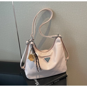 Detail of pink crescent hobo bag with silver triangle plaque and baseball charm