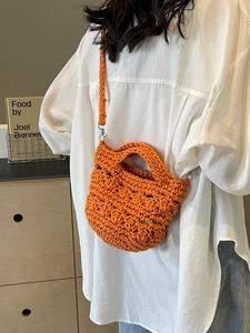 Handgefertigte orangefarbene gewebte Beuteltasche mit Flechtriemen am Model präsentiert