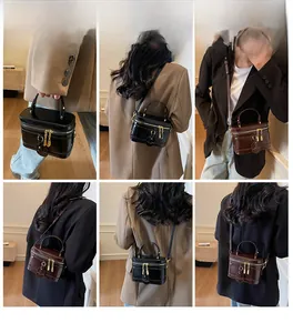 Retro Zylindertasche aus Leder in Schwarz und Braun mit edlen goldenen Beschlägen