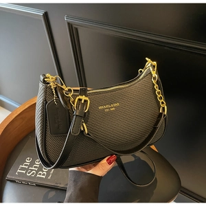 Detail of black woven shoulder bag featuring gold chain and signature brand plaque