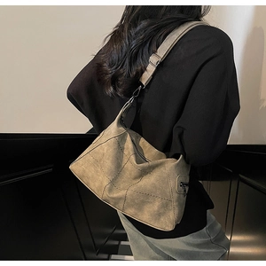 Detail of vintage patchwork shoulder bag showing adjustable strap and side zipper pocket