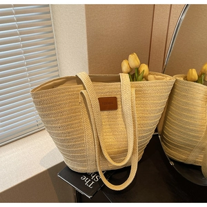 Detail of woven straw tote bag with brown leather FASHIONBAG patch and yellow tulips