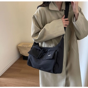 Detailopname van de zwarte nylon crossbodytas met verstelbare brede schouderband