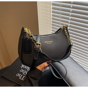 Detail of black hobo bag with woven texture, gold chain and brand logo on front