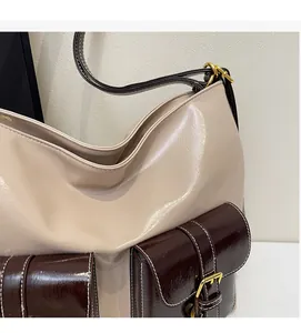 Détail du sac hobo en cuir synthétique beige avec poches extérieures marron contrastées