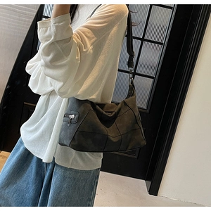 Detail of dark grey patchwork hobo bag featuring matte finish and vintage stitching