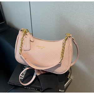 Detail of pink woven texture hobo bag with golden chain and metallic logo accent