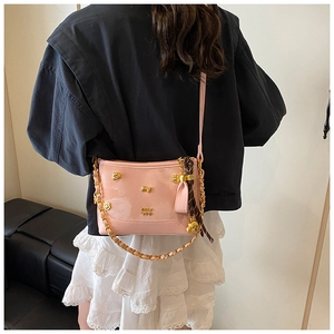 Pink patent leather tote with gold chain strap and printed scarf detail shown on model