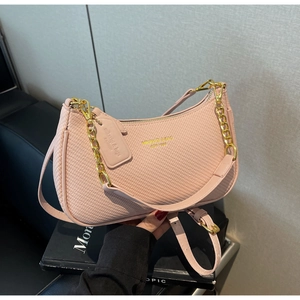 Detail view of pink woven shoulder bag with gold chain and refined texture finish