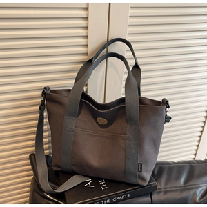 Detail view of charcoal canvas tote bag showing the texture and adjustable shoulder strap
