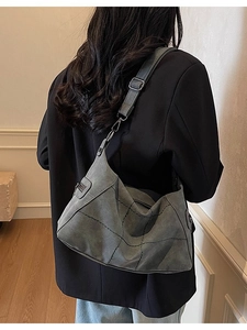 Retro grey frosted shoulder bag with contrast stitching and adjustable strap worn by model