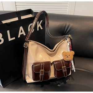 Détails des surpiqûres et des poches à boucles sur le sac à bandoulière rétro bicolore