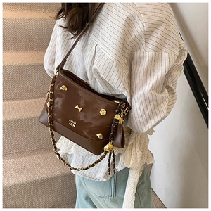 Close-up of brown PU leather tote with golden dog metal charms and chain strap