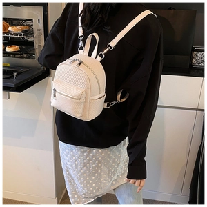 Close-up of cream woven mini backpack featuring silver hardware and adjustable straps