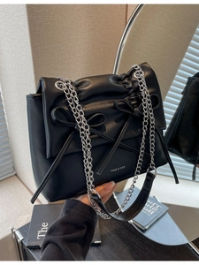Black matte leather shoulder bag with decorative bows and silver chain straps