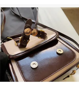 Dettaglio della borsa vintage bicolore con doppia fibbia magnetica dorata e pelle