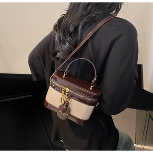 Details der Vintage-Box-Tasche mit goldenen Reißverschlüssen und Kontrastleder-Optik