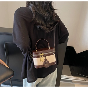 Detailansicht einer Vintage-Kosmetiktasche in Braun und Beige von einem Model getragen