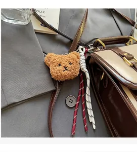 Portachiavi orsetto di peluche marrone su borsa in pelle retrò con dettaglio corda intrecciata