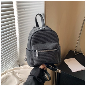 Detailed macro view of the black mini backpack featuring premium woven twill texture
