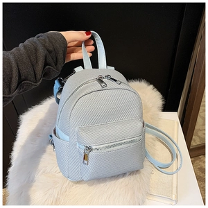 Detail view of mini light blue backpack with woven texture and silver dual zippers