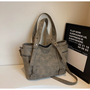 Close-up of vintage dark grey tote bag featuring aged leather texture and zipper detail