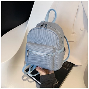 Close-up of light blue mini backpack with woven texture and silver hardware accents