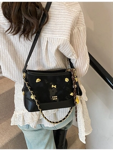 Chic black PU tote bag with gold puppy hardware and chain strap shown on model