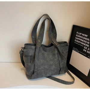 Detail of vintage grey-green marble texture tote bag with metallic rivet accents
