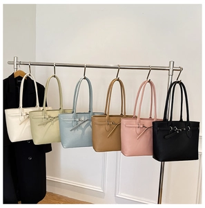 Vue détaillée de sacs cabas en six couleurs, dont beige, vert et bleu, sur un support