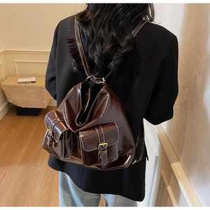 Vue détaillée du sac à dos en cuir marron foncé brillant avec coutures contrastées