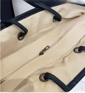 Close-up of beige canvas lining and antique bronze zipper of the straw tote bag
