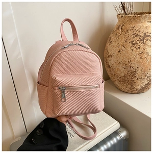 Close-up of pink mini backpack featuring premium woven texture and multi-pocket design