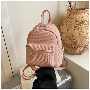 Detail of pink woven texture mini backpack with silver zippers and stylish front pocket