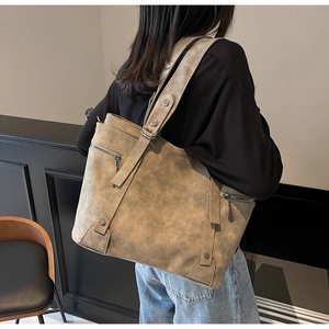 Detail of vintage khaki tote bag with front zipper and wide strap on model
