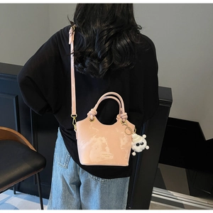 Rosa Eimertasche mit Marmortextur, Knotengriff und Plüschtier-Anhänger am Modell
