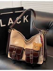 Sac fourre-tout beige avec poches marron et breloque ours en peluche sur fond de studio