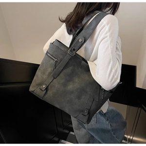 Macro detail of the dark grey matte tote bag showing side zipper and reinforced handle