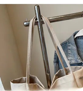 Detail view of the long smooth canvas shoulder strap on this minimalist tote bag