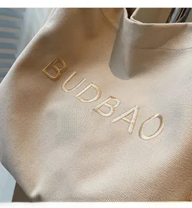 Close-up of cream canvas tote bag featuring high-quality BUDBAO letter embroidery