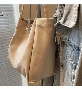 Detail of beige canvas tote bag featuring premium BUDA embroidery and clean side seams